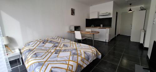 a bedroom with a bed and a table and a kitchen at Dampierre Studio 300 m du CNPE in Dampierre-en-Burly