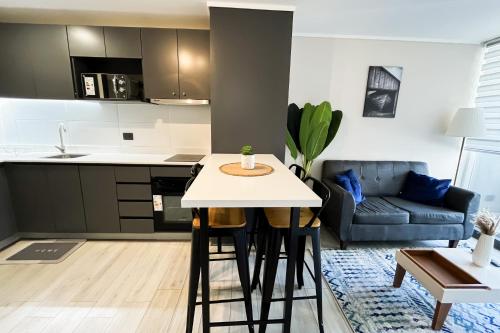 eine Küche und ein Wohnzimmer mit Tisch und Stühlen in der Unterkunft Apartamento en Ñuñoa, estacionamiento, Estadio Nacional, Piscina in Santiago