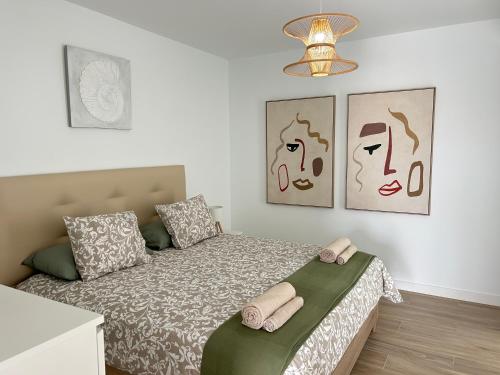a bedroom with a bed and two pictures on the wall at Mariposa Blanca in Villaverde