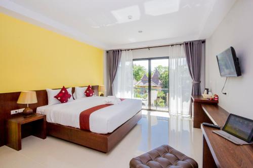 a bedroom with a bed and a tv and a window at Andaman Pearl Resort in Ao Nang Beach