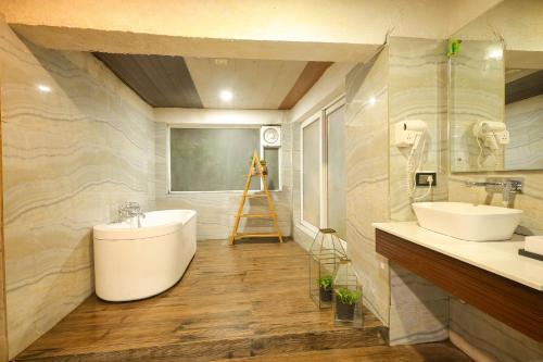 bagno con 2 lavandini e vasca di Nanau Resort & Spa a Ramnagar