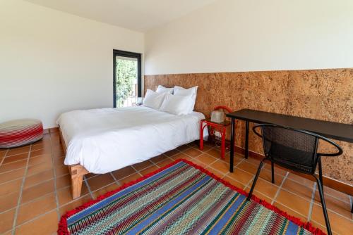a bedroom with a bed and a table and a rug at Calipo in Vila Viçosa