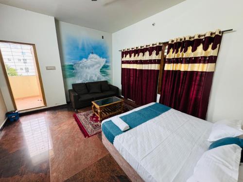 a bedroom with a bed and a couch and a window at LUXE Penthouse 4BHK with Swimming pool in Mysore