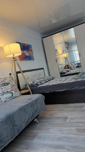 a room with two beds and a lamp and a mirror at Однокомнатная квартира в центре города in Balqash