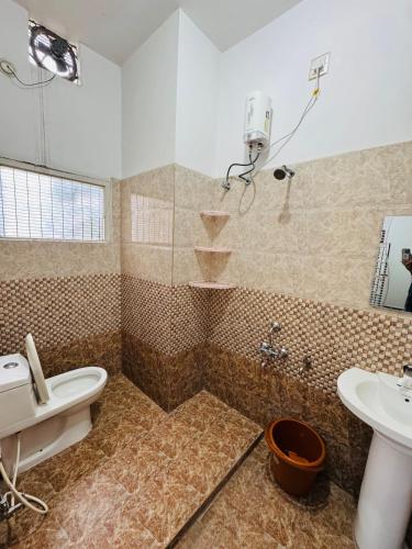 a bathroom with a toilet and a sink at LUXE Penthouse 4BHK with Swimming pool in Mysore