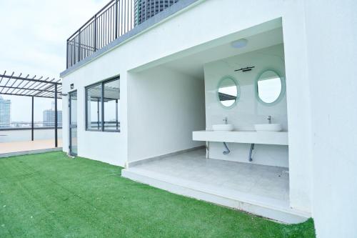 a white bathroom with two sinks and a green lawn at Orchid Residency, Westlands in Nairobi