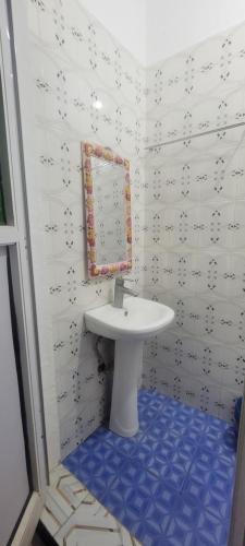 a bathroom with a white sink and a mirror at Paul's House in Nungwi