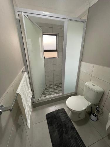 a bathroom with a toilet and a walk in shower at Vation Nation Guest House in Mokopane