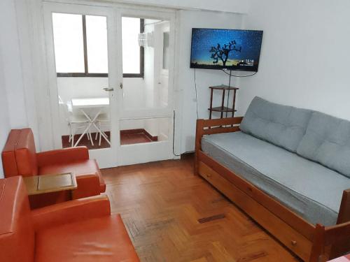 a living room with a couch and a chair at Depto para 6 personas playa grande con seña in Mar del Plata