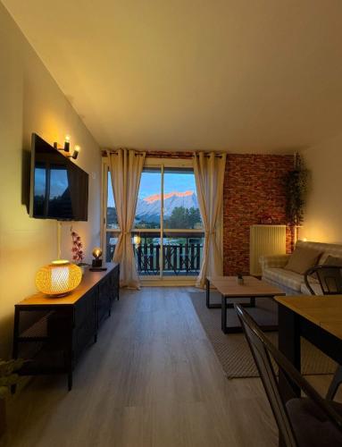 a living room with a couch and a television at cosystudio Superdevoluy 5pers pied des pistes in Le Dévoluy