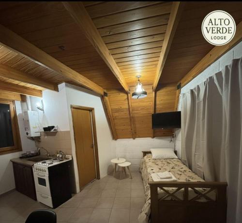 a small room with a bed and a sink in it at ALTO VERDE Lodge in Potrero de los Funes