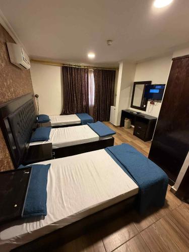 a hotel room with four beds and a flat screen tv at فندق برستيج العقبه Prestig in Aqaba