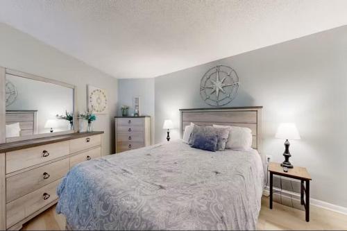 a bedroom with a bed and a clock on the wall at Relaxing Oceanfront 2BR Beach Condo! Royal Garden 1514 in Myrtle Beach