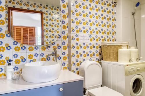 a bathroom with a sink and a toilet and a mirror at Aida's Place, a Home in Madeira in Ilhéu do Gorgulho