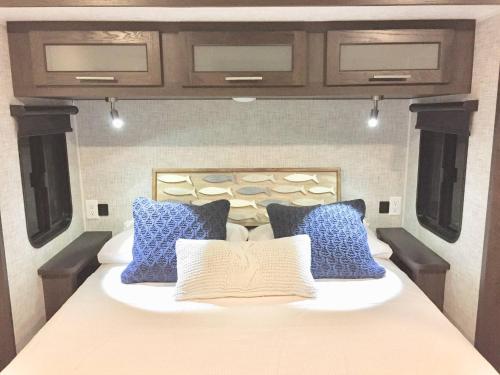 a bed in a rv with blue and white pillows at 2 BR/2 BA Oasis Kayakes, Pool, Beach & Dock Rental in Key Largo
