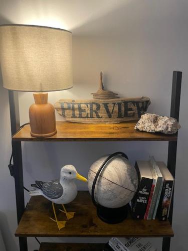 a bird on a shelf with a lamp and a ball at Pier View in Lytham St Annes