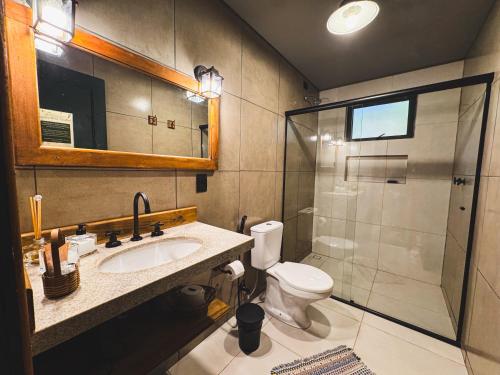 a bathroom with a toilet and a sink and a shower at Pousada Sitio da Terra e Arte in São Roque