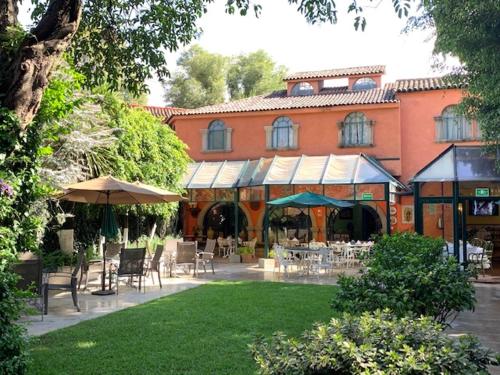 a courtyard with tables and chairs and a building at Hotel Park Villa in Mexico City