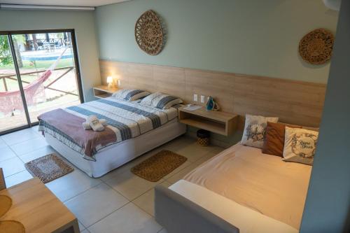 een slaapkamer met twee bedden en een groot raam bij AP Villas Bobz Barra Grande-PI in Barra Grande