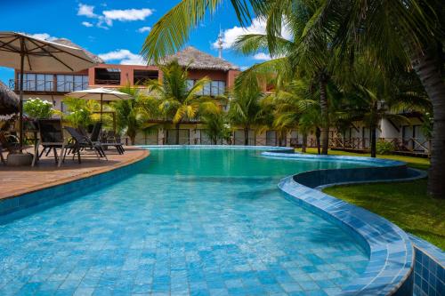 een zwembad op een resort met palmbomen bij AP Villas Bobz Barra Grande-PI in Barra Grande