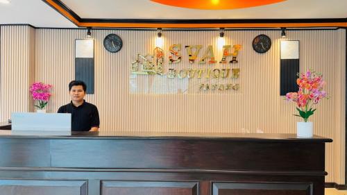a man standing behind a counter in a restaurant at SVAH Boutique Patong in Patong Beach