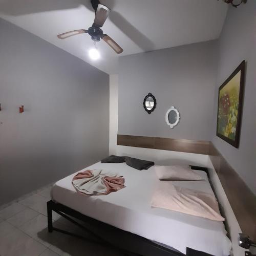 a bedroom with a bed with a ceiling fan at Pousada Rout Bikers Penedo in Penedo