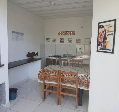 a kitchen with a table and chairs in a room at Pousada Costeira Barra do Sul in Balneario Barra do Sul