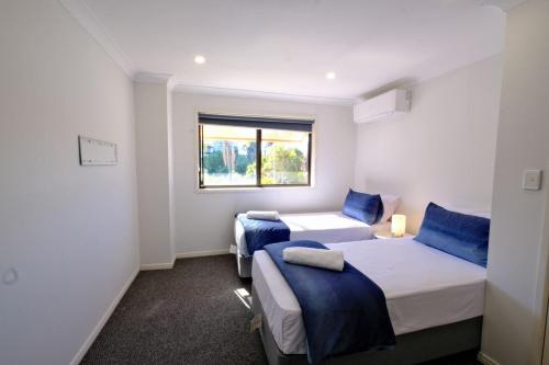 a room with two beds and a window at 2-Bedroom Apt with Terraces in Gold Coast