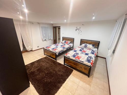 a bedroom with two beds and two rugs at La casa del sole in Valfenera