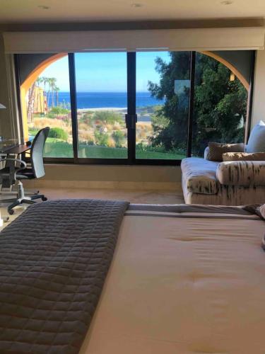 a bedroom with a bed and a desk and a window at Gorgeous Casa del Mar Condo in Cabo San Lucas