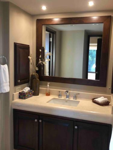 a bathroom with a sink and a large mirror at Gorgeous Casa del Mar Condo in Cabo San Lucas