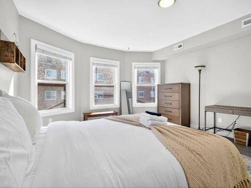 une chambre blanche avec un lit et deux fenêtres dans l'établissement Luxury 3BR 2BA Boston Penthouse, à Boston