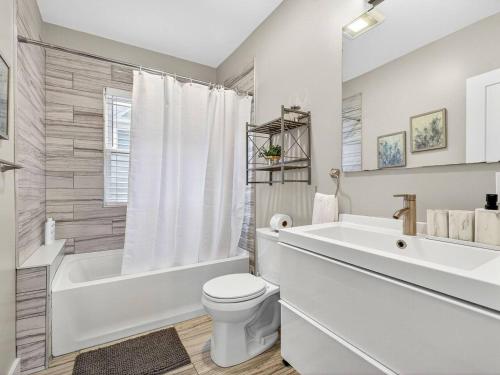 une salle de bain blanche avec une baignoire et des toilettes dans l'établissement Luxury 3BR 2BA Boston Penthouse, à Boston