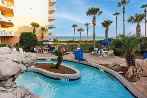 une piscine dans un complexe hôtelier avec des palmiers dans l'établissement NEW Beachfront Bliss- Sleeps 8, 2 Pools, Lazy River, à Fort Walton Beach