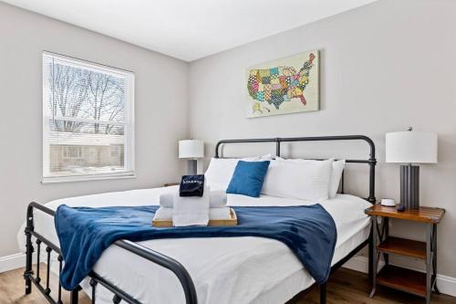 a bedroom with a bed with a blue blanket at Completely Renovated Home in St. Charles, Missouri in Harvester