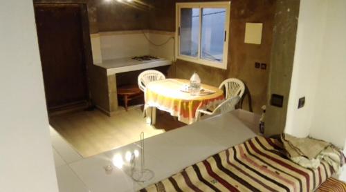 a room with a table and chairs and a table and a bed at Refuge AIT M'HAMED in Aït Mehammed