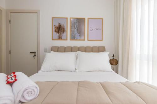 een slaapkamer met een groot bed met witte kussens bij Apartamento de 1 Quarto com Sofa-Cama - CEN1104 in Curitiba