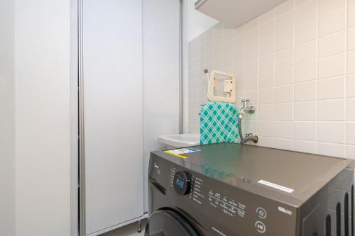 een kamer met een wasmachine in een badkamer bij Apartamento de 1 Quarto com Sofa-Cama - CEN1104 in Curitiba