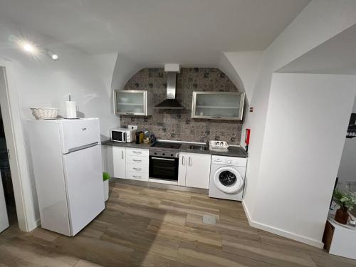 a kitchen with a white refrigerator and a dishwasher at Casa dos Albardeiros in Moura