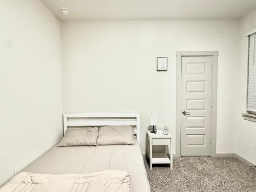 a white bedroom with a bed and a white door at Peaceful Room in Austin in Austin