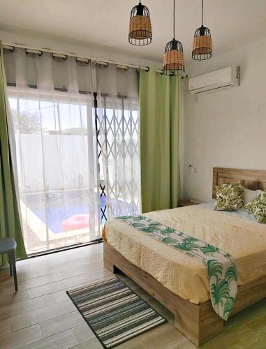 a bedroom with a bed and a large window at Marbella villas 2 in Grand Baie
