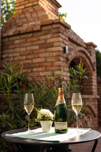 a bottle of wine sitting on a table with two glasses at Vila Maria II in Vinkovci