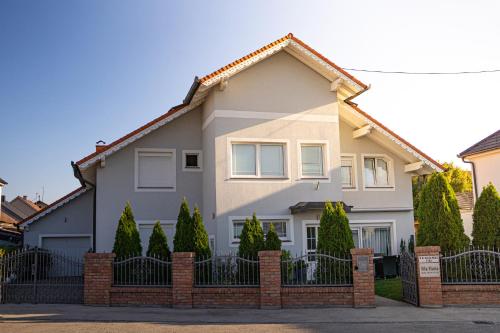 a house with a fence in front of it at Vila Maria II in Vinkovci