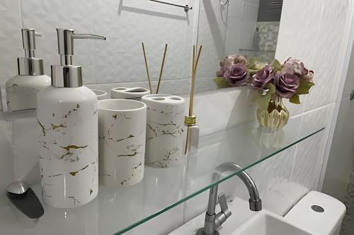 a bathroom with three rolls of toilet paper on a counter at Eficiência - Casa da Lidu in Camocim
