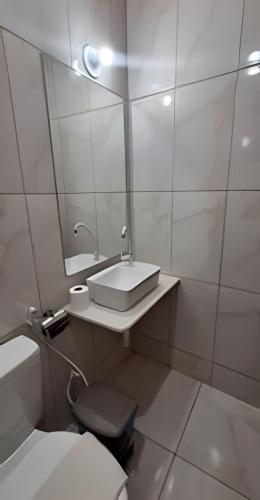 a bathroom with a sink and a toilet and a mirror at Eficiência - Casa São Pedro - Casa Beira Mar in Camocim