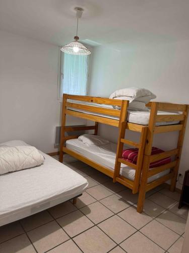 a bedroom with two bunk beds and a window at Pyrenees family T3 in Aulus-les-Bains