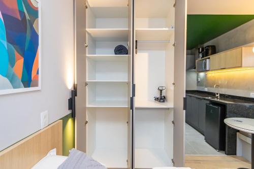 a small kitchen with white cabinets and a sink at Studio Super Completo em Região Tranquila -EIX0202 in Curitiba