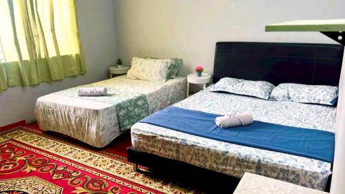 a bedroom with two beds and a red carpet at BlackSands Guests House Langkawi in Huma