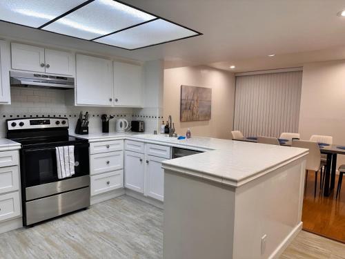 a kitchen with white cabinets and a counter top at Venice Beach Lux Retreat Coastal Apartment Haven in Los Angeles
