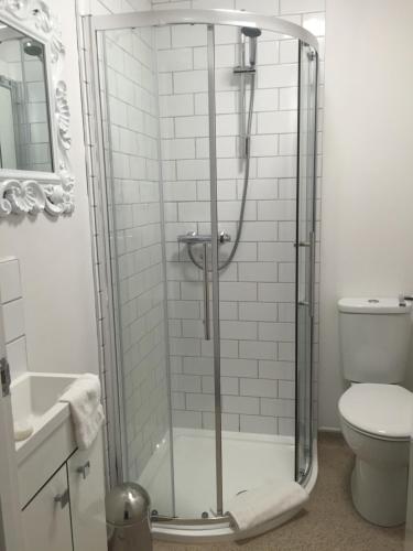 a bathroom with a shower with a toilet and a sink at The Crown Inn in Towcester